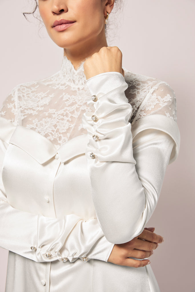Woman wearing off-white silk charmeuse bridal shirt dress with pearl buttons