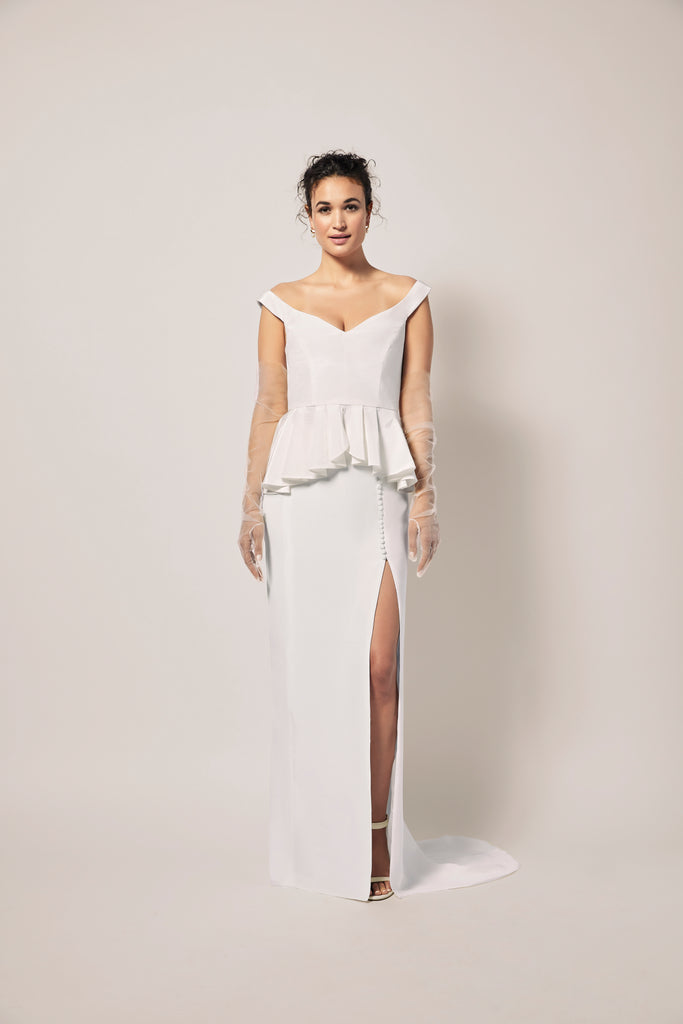 woman wearing off-white straight long skirt in a heavy silk crepe with a front side slit and peplum top