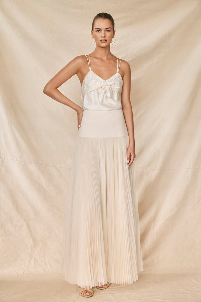 Woman wearing ivory pleated bridal skirt and silk top