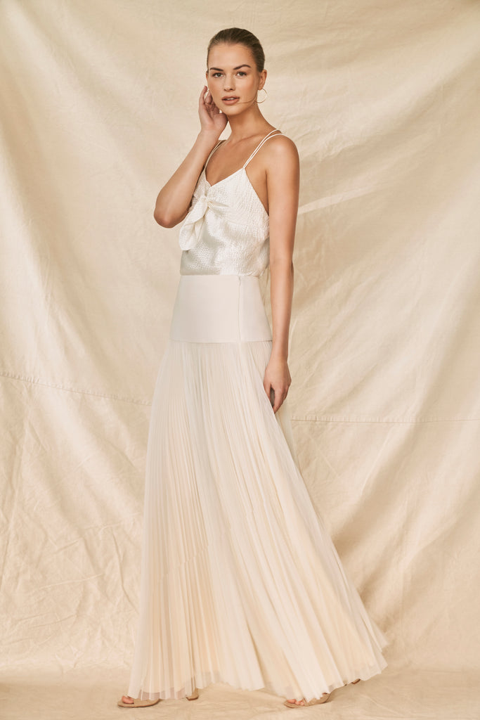 Woman wearing ivory pleated bridal skirt and silk cami top