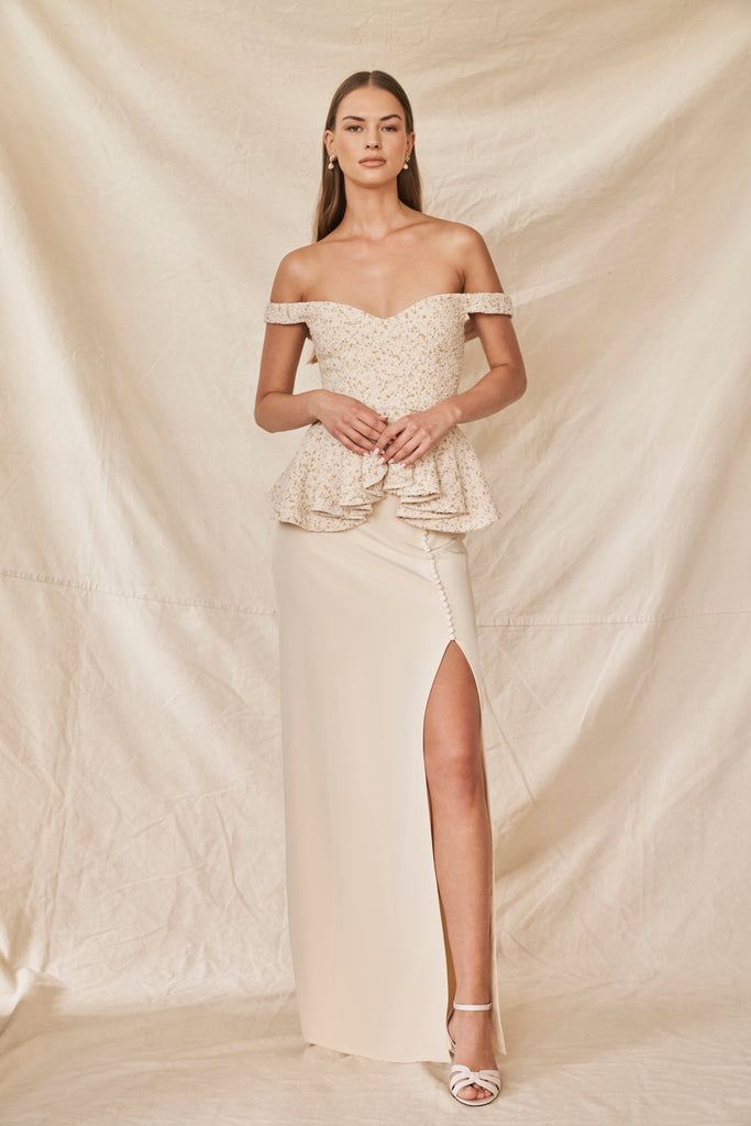 Woman wearing silk crepe wedding skirt with a front side slit and peplum top