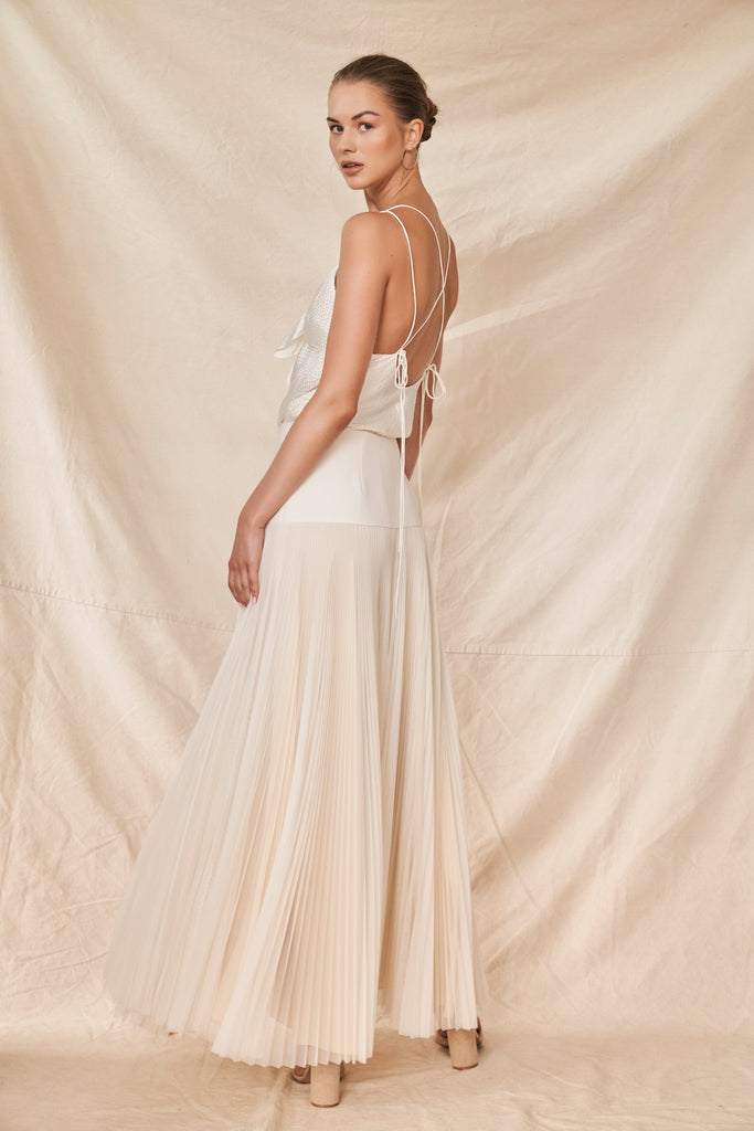 Woman wearing ivory pleated bridal skirt and top with spaghetti straps
